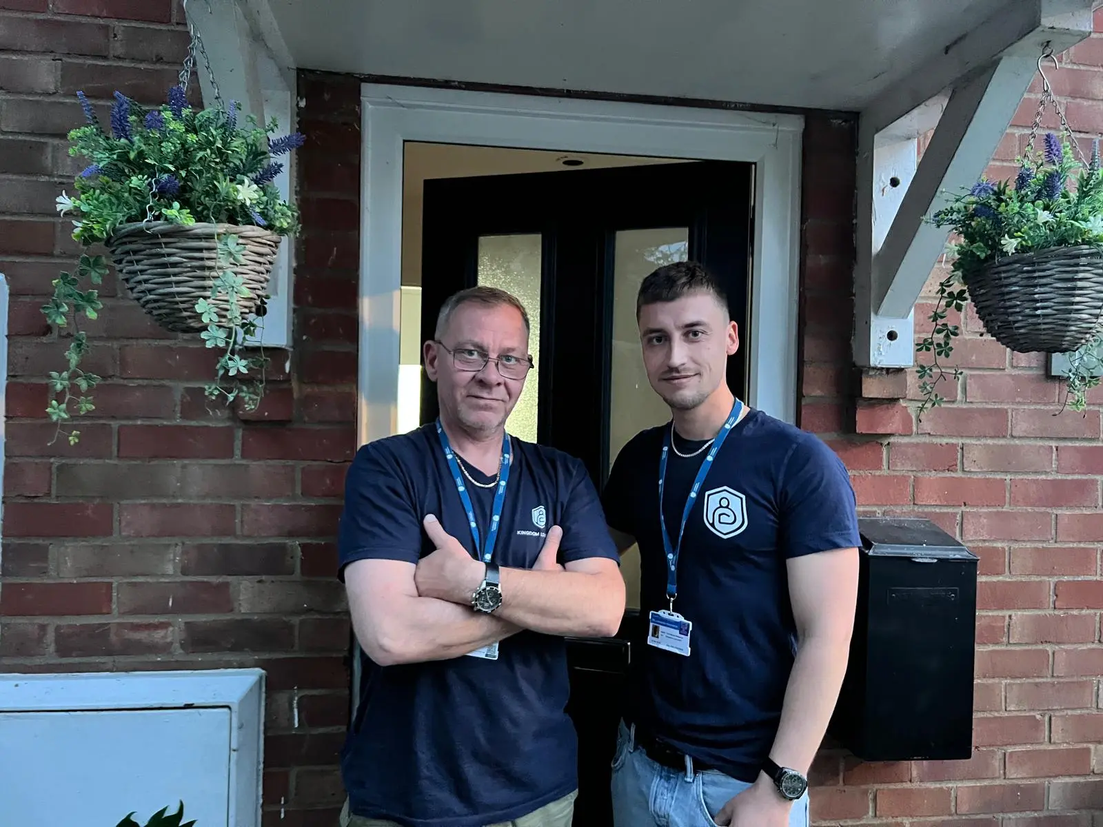 Two Kingdom Locksmith engineers in branded uniforms at a customer’s front door